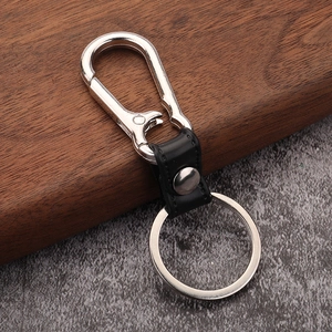 Detail of silver spring carabiner and black leather strap for metal car keychain