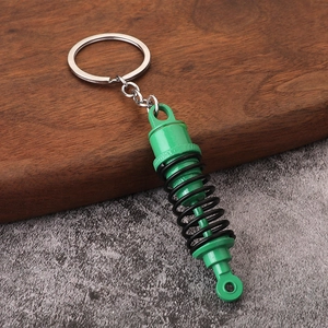 Dettaglio di un portachiavi creativo in metallo verde a forma di ammortizzatore d'auto