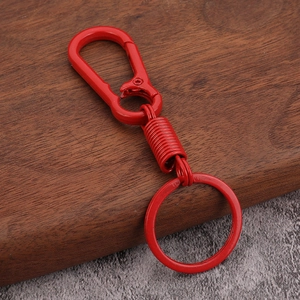 Detail of red metal spring keychain showing the durable carabiner and glossy finish
