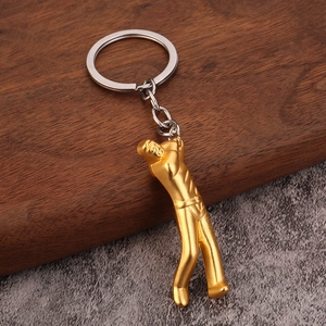 3D golden golf player keychain with silver chain on premium dark wood surface