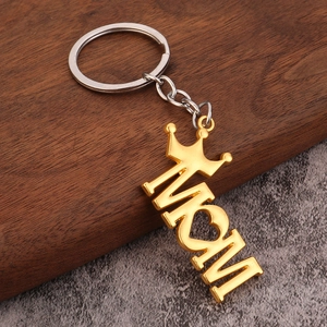 Gouden Mom sleutelhanger met kroon en hart op houten en stenen ondergrond