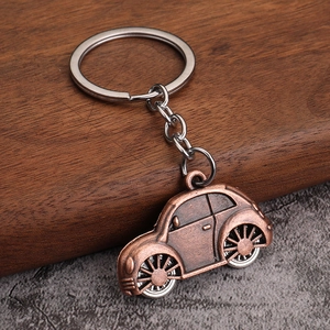 Close-up of vintage bronze beetle car keychain with detailed metallic texture and key ring
