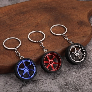 Three premium metal car wheel rim keychains in blue, red, and grey with rubber tires
