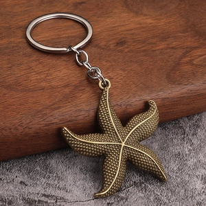 Vintage bronze starfish pendant keychain with metallic texture on rustic wooden background