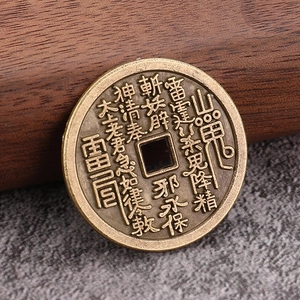 Antique bronze cinnabar coin with relief Taoist inscriptions on textured background