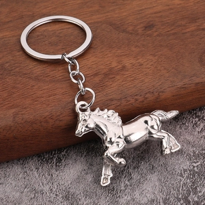 Silver metal horse keychain with dynamic running pose on a textured background