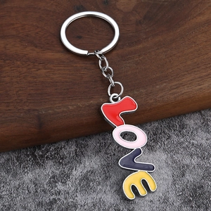 Colorful LOVE letter keychain with metal lobster clasp on a textured wooden background