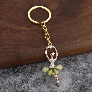 Golden ballet dancer keychain pendant with green crystal skirt and white rhinestones