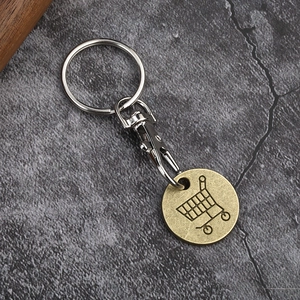 Metal trolley token keychain with lobster clasp on dark marble background
