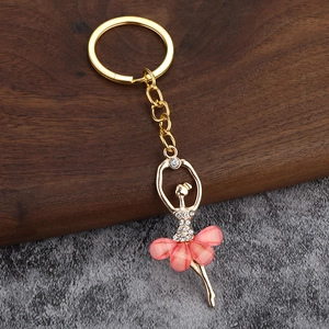 Detail of golden ballet dancer charm with pink petal skirt and sparkling rhinestones