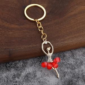 Macro shot of gold-plated ballerina keychain with red dress and sparkling crystals
