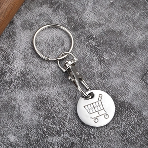 Macro shot of silver metal shopping trolley coin keychain with lobster clasp on stone surface