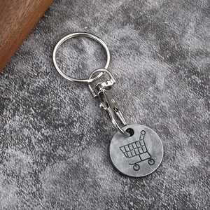 Detail shot of a metal shopping trolley coin keychain with lobster clasp and engraved icon