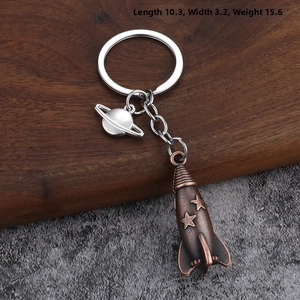 Detailed view of bronze rocket and silver Saturn pendants with product dimensions