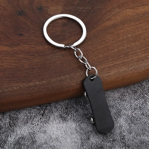 Macro detail of the mini black skateboard pendant with realistic silver metal wheels