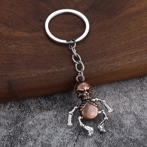 Vintage bronze and silver alloy robot skeleton keychain on a rustic wood background