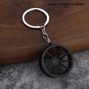 Matte black car wheel hub keychain on wood background, size 3.9x3.6cm, weight 17.5g