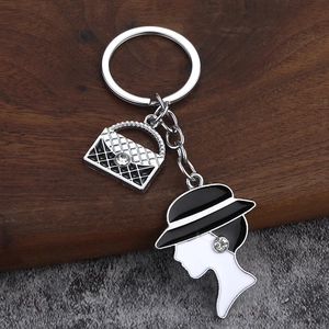 Chic silver metal keychain with quilted handbag and elegant lady silhouette charms