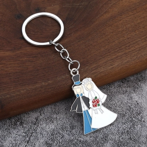 Détail des breloques de mariés en émail sur un porte-clés de mariage en métal argenté
