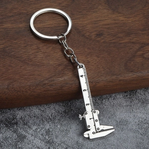 Macro shot of silver zinc alloy mini vernier caliper keychain with precise scale detail