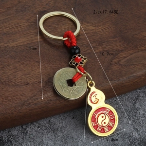 Détail du porte-clés gourde en émail rouge avec symboles Bagua et pièce ancienne