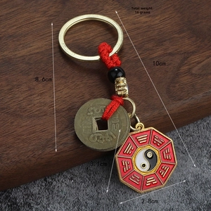 Détail d'un porte-clés chinois avec pièces en laiton, nœud rouge et pendentif Bagua