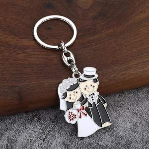 Détail du porte-clés de mariage émaillé mariés sur une surface texturée