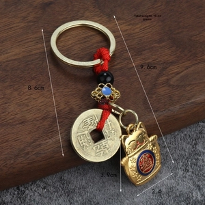 Détail d'un porte-clés en alliage avec chat porte-bonheur et pièce de monnaie