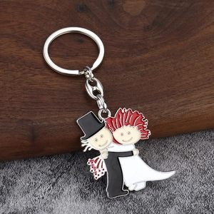 Détail d'un porte-clés en métal émaillé créatif avec un charm de mariage mariés cartoon