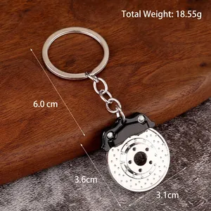 Zinc alloy brake disc keychain with black caliper on a rustic wooden surface