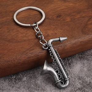 Détail macro du porte-clés saxophone en argent antique sur fond de pierre de qualité