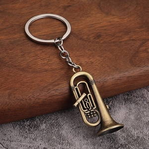 Porte-clés instrument de musique trompette en bronze vintage sur fond bois rustique