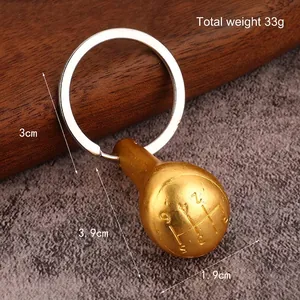 Miniature manual gear shifter keychain in matte gold finish with 6-speed engraving