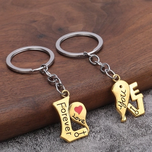 Close-up of gold and silver heart-shaped couple keychains with Forever Love engraving