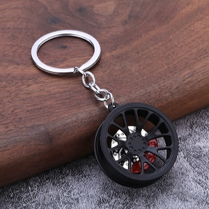 Close-up of car wheel rim keychain with silver brake disc and red brake caliper detail