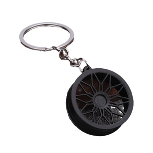 Porte-clés jante de voiture sport noire avec anneau métallique sur fond blanc pur