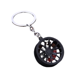 Black wheel rim keychain with red brake caliper detail on white background