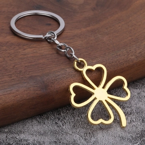 Detailed close-up of hollow four-leaf clover keychain with gold and silver metal finish