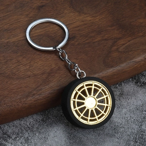 Creative automotive wheel rim keychain with gold spokes and black rubber tire texture