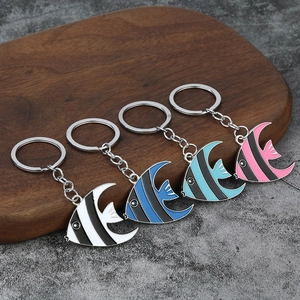 Set di quattro portachiavi a forma di pesce tropicale in smalto colorato su vassoio in legno