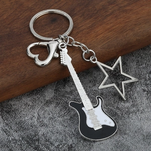 Close-up of black electric guitar keychain with star charm and heart-shaped clasp