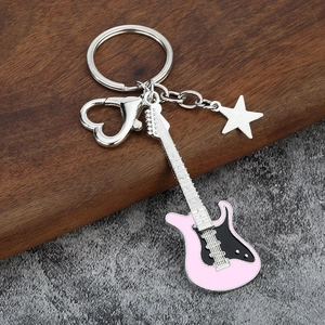 Detail of pink and black guitar keychain with silver heart carabiner and star charm
