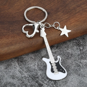Detailed macro view of electric guitar keychain with heart clip and star charm