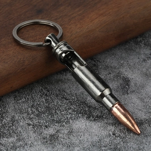 Bullet-shaped metal bottle opener keychain in gun grey finish on rustic background
