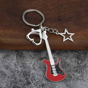 Detail of red electric guitar keychain with heart-shaped carabiner and star charm