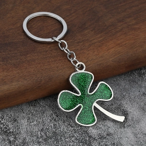Macro detail of sparkly green glitter clover keychain with silver metal chain