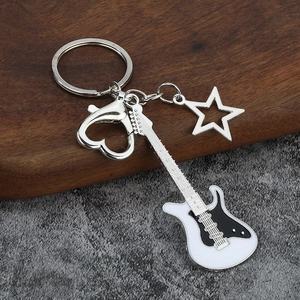 Guitar keychain with black and white enamel and heart lobster clasp on wooden background