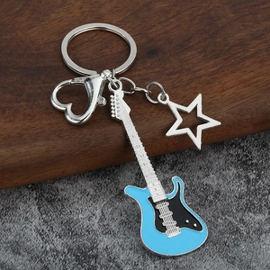 Detail of guitar keychain with blue enamel pendant, silver star, and heart-shaped carabiner