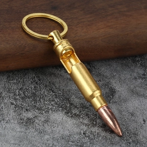 Macro detail of bullet shaped bottle opener keychain on a wooden and stone surface