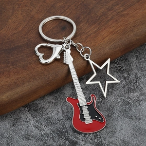 Detailed view of musical electric guitar keychain with star charm and heart clasp